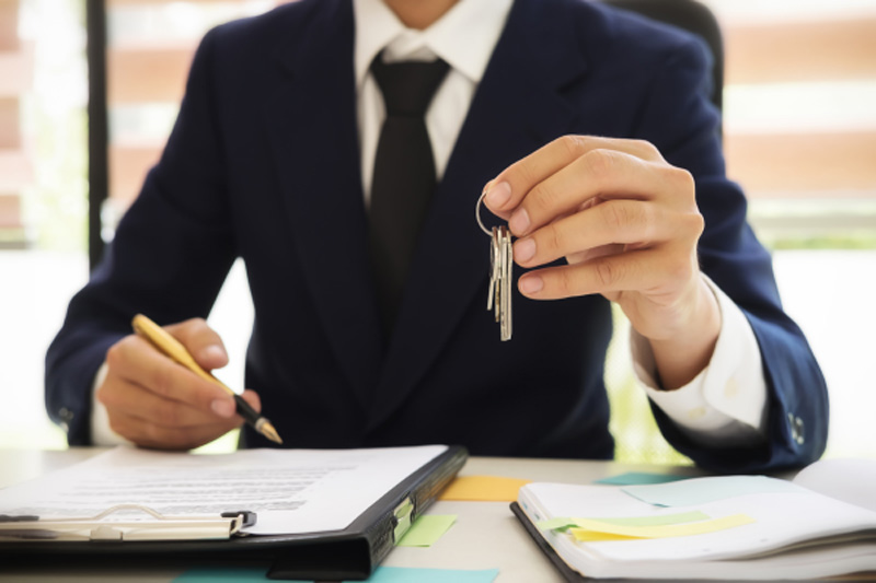 Immobilienmakler Eckenheim hält Schlüssel und Kaufvertrag in der Hand um Immobilie zu Verkaufen in Eckenheim